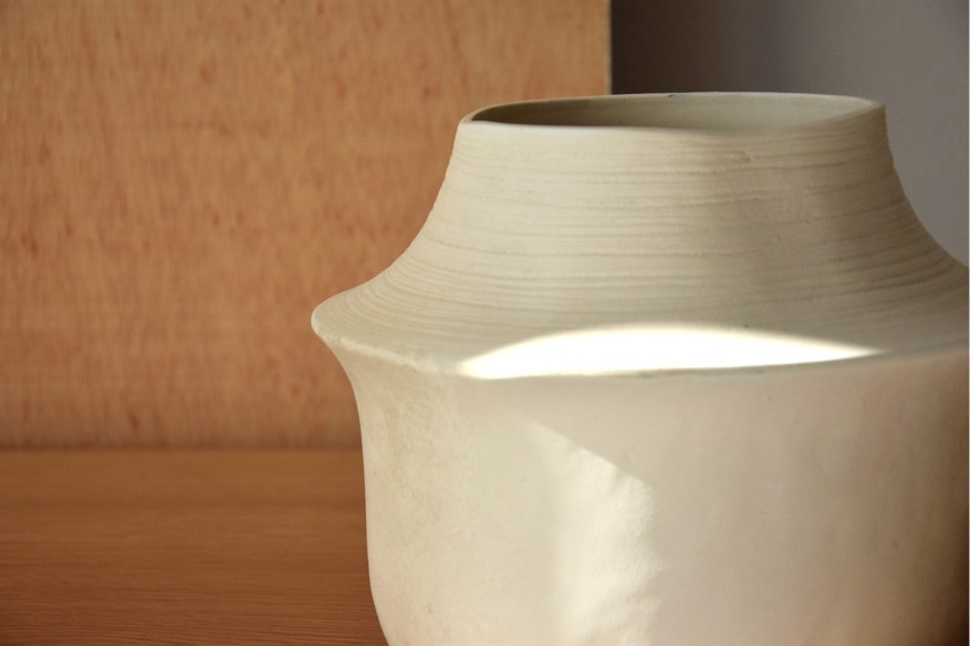 Jarrón blanco roto bajo Piedra